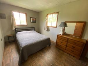 a bedroom with a bed and a dresser and a mirror at Hickory Grove Hideaway in Galmey