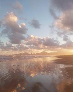 a beach with a cloudy sky and the water at Camping rock in Itanhaém