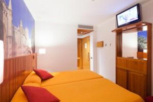 a bedroom with a bed with a television on the wall at Plaça De La Font in Tarragona