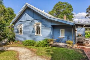 ein blaues Haus mit einem Garten davor in der Unterkunft Meroo Meadow Magic Charming Cottage Retreat in Meroo + 24 Fotos