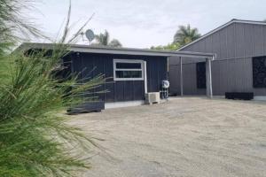 a blue building with a large yard in front of it at The Hidden Cottage in Papamoa