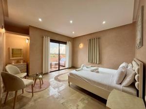 a bedroom with a bed and a desk and a window at Private Villa BSF - Hot Pool & Spa - Palm Golf in Marrakech +28 photos
