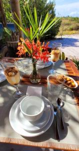 a table with a plate of food and wine glasses at karabe-bae Private Bungalows Remo in Praia dos Algodões