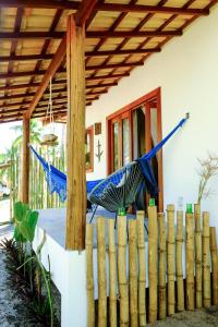 two blue umbrellas on a fence in front of a house at karabe-bae Private Bungalows Remo in Praia dos Algodões