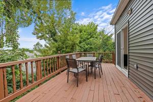 a wooden deck with a table and chairs on it at New Luxury House in the Heart of Janesville in Janesville