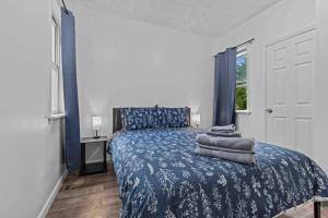 a bedroom with a bed with blue sheets and a window at New Luxury House in the Heart of Janesville in Janesville