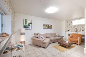 a living room with a couch and a table at Askegaarden Apartments in Sandved