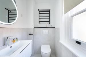 ロンドンにあるCozy Studios In The Heart Of Shoreditchのトイレと洗面台を備えた白いバスルーム