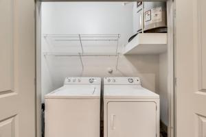 a small kitchen with two white appliances in a room at Tranquil 2BR I Pool I Gym I Parking I Workspace in Dallas +20 photos