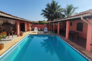 a swimming pool in front of a house at Recanto do Sol em Praia Seca in Araruama