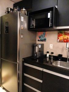 a kitchen with a stainless steel refrigerator and a sink at Luxury Paiva Flat in Recife
