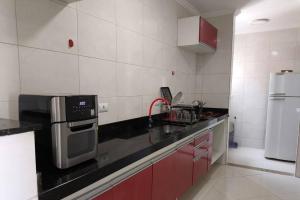 a kitchen with a sink and a refrigerator at Mareazul Ubatuba in Ubatuba