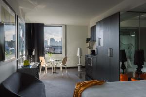 墨尔本The Cullen Melbourne - Art Series的一间带床、桌椅的酒店房间