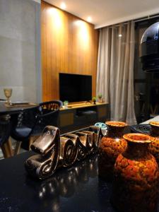 a table with three vases on top of a room at Luxury Paiva Flat in Recife