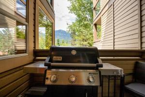 a grill in a screened in porch with a window at Ski In Ski Out 3BR Townhome in Creekside by Harmony Whistler in Whistler