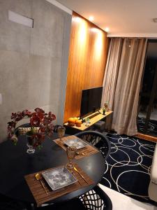 a living room with a table and a television at Luxury Paiva Flat in Recife