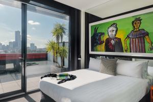 墨尔本The Cullen Melbourne - Art Series的一间带大床和大窗户的卧室