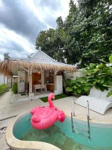 a pink rubber duck in a pool in front of a house at Sampai Villa Nayan in Yogyakarta +37 photos
