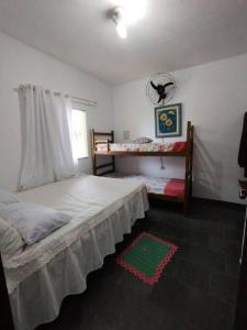 a bedroom with a bed and a window at Canto Verde casa de veraneio, férias e piscina in Cananéia