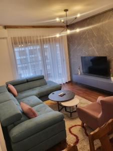 a living room with a couch and a tv at Master apartment in Kruševac