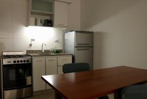 una cocina con una mesa y un refrigerador en Amplio monoambiente con piscina, en Buenos Aires