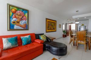 ein Wohnzimmer mit einem roten Sofa und einem Esszimmer in der Unterkunft Cartagena - Torremarina in Cartagena de Indias