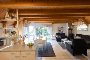 a living room with a kitchen and a living room with a table at Ferienhaus "Nanni" Wittsand 04 in Dorum-Neufeld