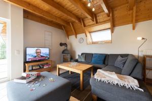 a living room with a couch and a tv at Ferienhaus Nordertill 11 in Dorum Neufeld