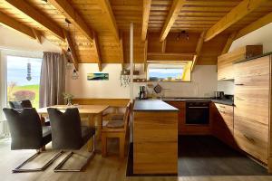 a kitchen with wooden ceilings and a table and chairs at Ferienhaus "Sprenger" Hans Albers 11 in Wremen