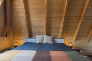a bed in a wooden room with two pillows at Ferienhaus "Wattwurm" Mellumplate 39 in Dorum Neufeld