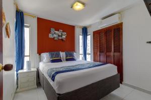 ein Schlafzimmer mit einem großen Bett mit orangefarbenen Wänden in der Unterkunft Cartagena - Torremarina in Cartagena de Indias + 31 Fotos