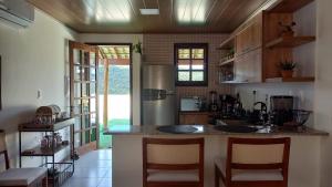 une cuisine avec un comptoir et des chaises. dans l'établissement Casa Ipê, à Lençóis