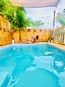 a woman in a bikini sitting next to a swimming pool at Magayon viewpoint in Damasanan