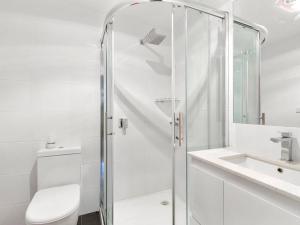 a bathroom with a shower and a toilet and a sink at Silverleaves on the Beach in Rhyll