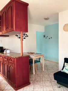 cocina con armarios rojos y mesa de madera en Tartaruga Ubatuba, en Ubatuba
