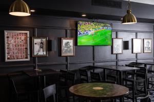 a dining room with tables and a large screen television at Camelia Grove Hotel in Sydney