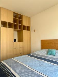 ein Schlafzimmer mit einem Bett und Holzschränken in der Unterkunft Habitación privada en zona residencial, El Marques in Miranda