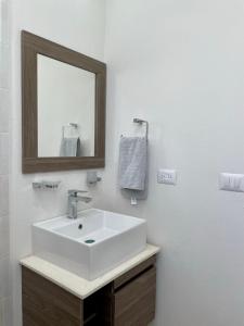 ein Badezimmer mit einem weißen Waschbecken und einem Spiegel in der Unterkunft Habitación privada en zona residencial, El Marques in Miranda
