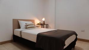 a bedroom with a large bed with a lamp on a table at Apartasuites ISABEL in Cali +19 photos
