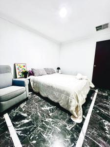 a white bedroom with a bed and a couch at 28 OFF Affordable Beautiful Queen Bedroom Near City Swan River Fremantle University in Perth