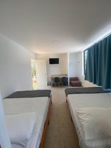 a room with two beds and a living room at Villa Panoramica 2 pisos, piscina vista al mar in Acapulco