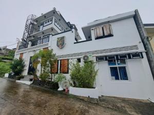 a white house with plants in front of it at Room at Arthur Resort in Legazpi