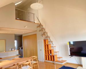 新居滨市The Global Tower的一间带餐桌和楼梯的客厅