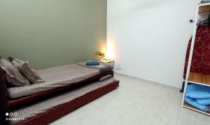 a small bedroom with a bed and a shelf at Homestay Kuala Terengganu Baroqah Homestay in Kuala Terengganu +2 photos