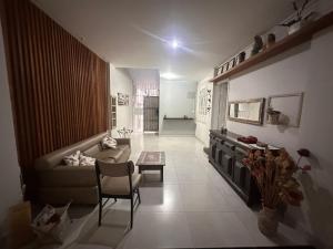 a living room with a couch and a table at Pousada 10 de maio in Itaperuna
