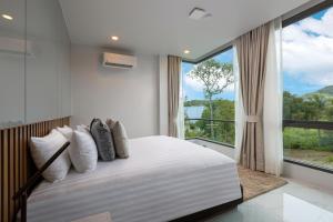 a bedroom with a large bed with a large window at MANDLA VILLAS COLLECTION, Villa Tanya Rawai in Rawai Beach +97 photos