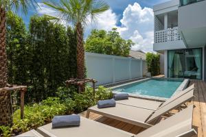 a backyard with a swimming pool and a house at MANDLA VILLAS COLLECTION, Villa Tanya Rawai in Rawai Beach