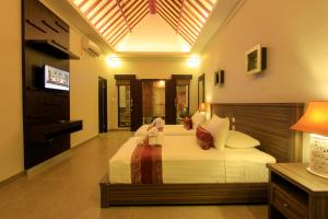 a bedroom with a bed with two stuffed animals on it at Griya Shanti Villas & Spa in Ubud