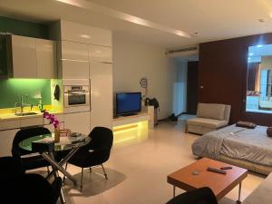 a living room with a bed a table and a kitchen at Ananya Beachfront Wongamat Paradise in North Pattaya