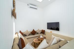 a living room with a couch and a tv at Villa Flambard in Canggu